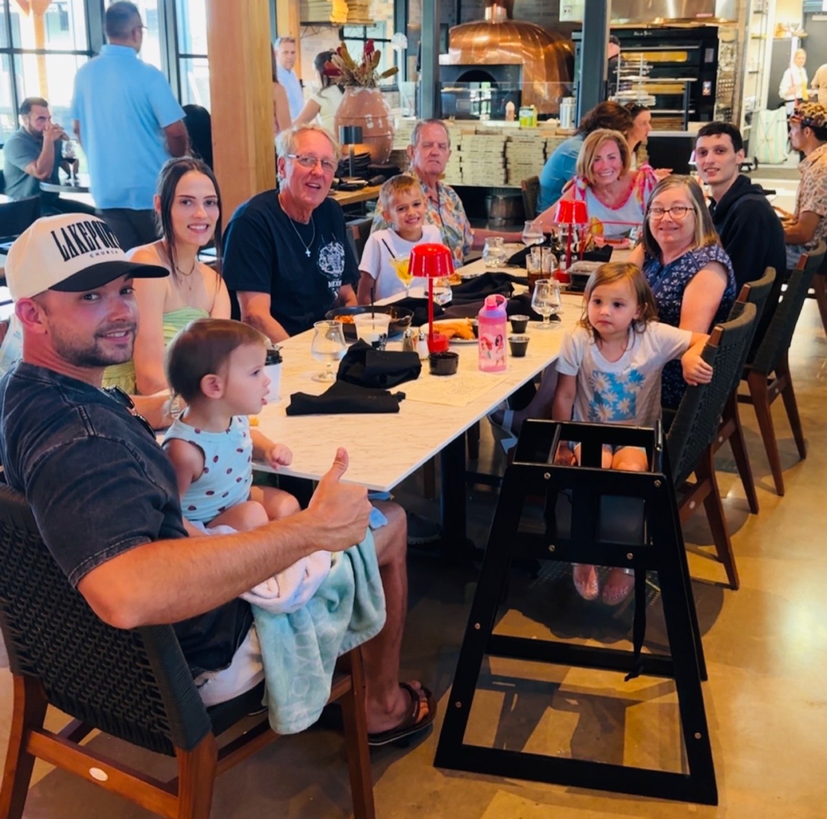 Tyler, owner of Gentle Contracting LLC, with his family at a restaurant table in the Rockwall, Texas area