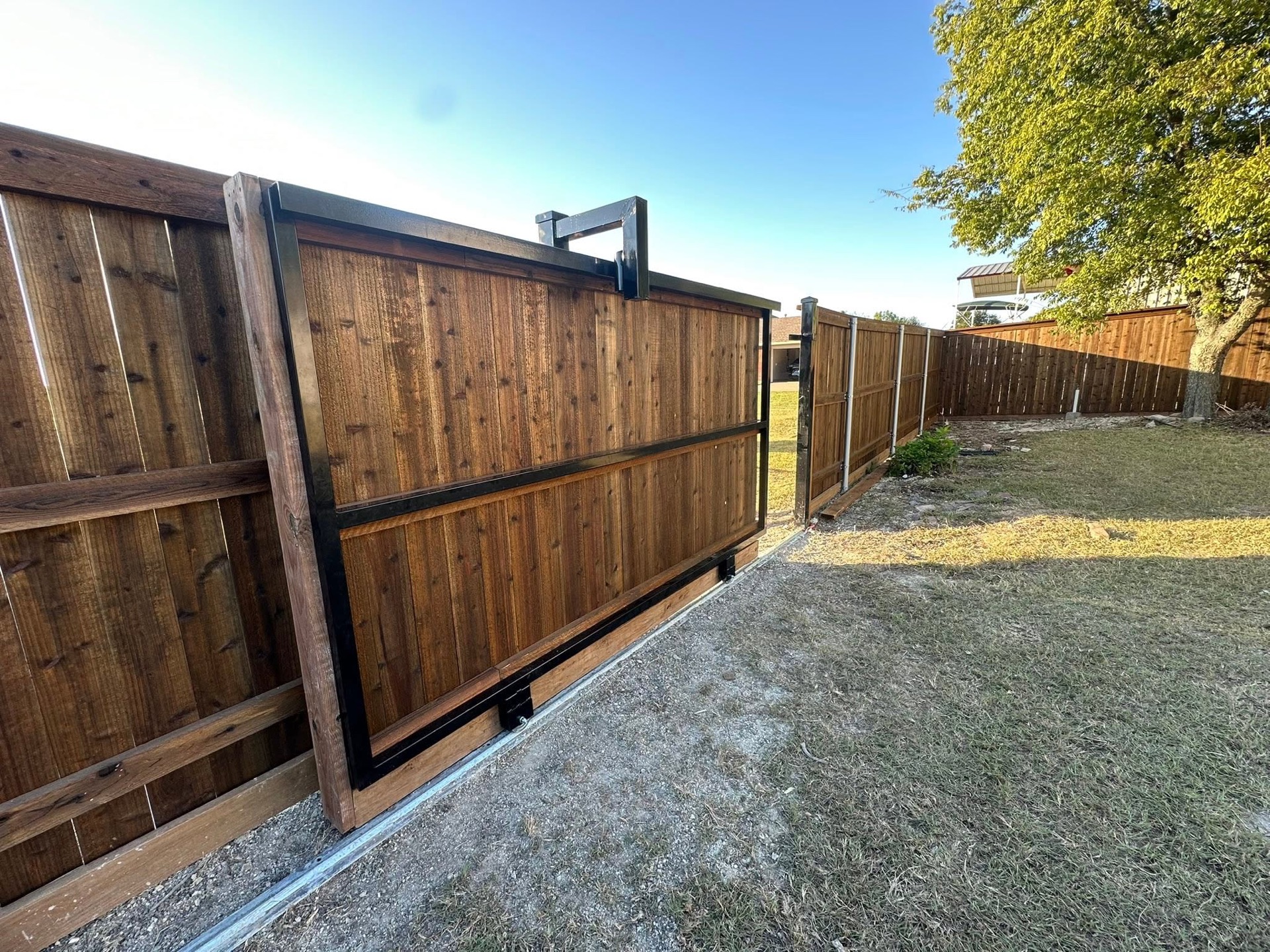 Wood fence with a steel-framed sliding driveway gate built by Gentle Contracting in the Dallas Fort Worth area